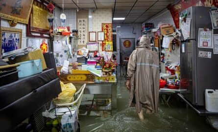 A resident wearing a raincoat in a flooded home