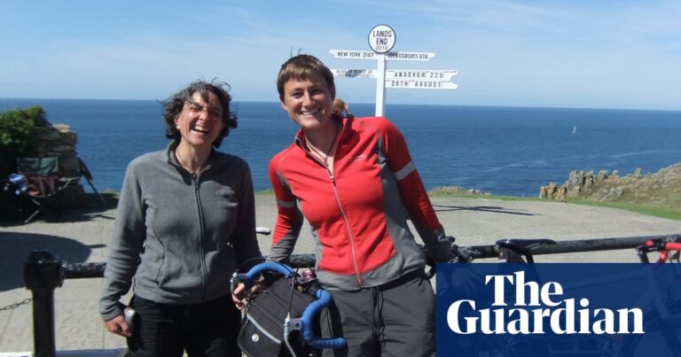 The couple with their bikes in front of a sign