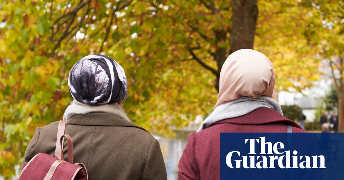 Two Muslim women walking in a park