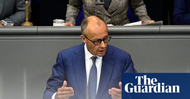 Friedrich Merz gestures with both hands while speaking at a podium in the Bundestag