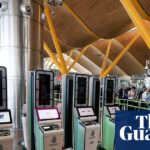 Automated EES kiosks stand near a queue of travellers at Madrid's Barajas Airport