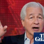 Jamie Dimon gestures with his raised hand while speaking during a TV interview