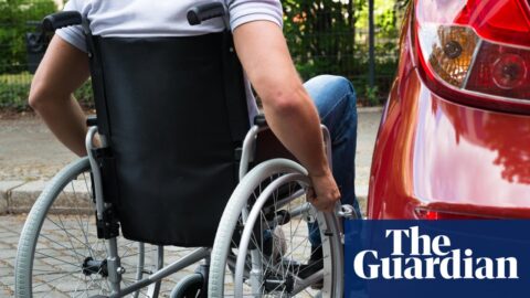 Close-up of a man sitting on a wheelchair near a car