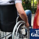 Close-up of a man sitting on a wheelchair near a car
