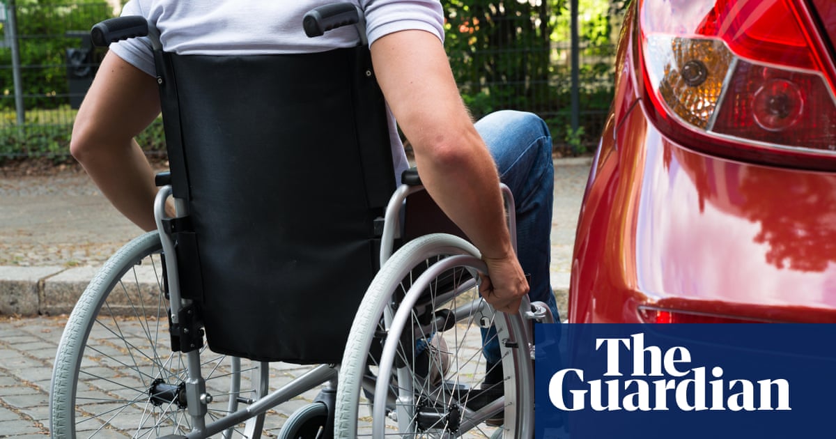 Close-up of a man sitting on a wheelchair near a car