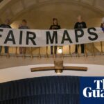 Activists display signs during a press conference inside the rotunda of the Missouri State Capitol.