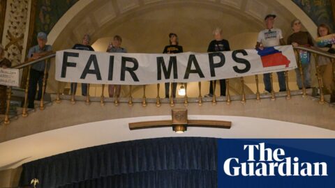 Activists display signs during a press conference inside the rotunda of the Missouri State Capitol.