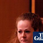 Death row inmate Christa Pike, in red jumpsuit, walks ahead of an officer in court