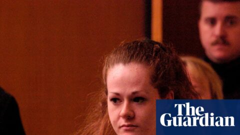 Death row inmate Christa Pike, in red jumpsuit, walks ahead of an officer in court