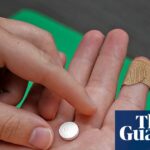 A close-up of hands holding a mifepristone pill above an open palm