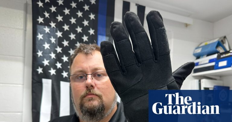 a man in uniform wears a bulky black glove