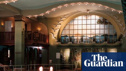 Swimmers in Centralbadet's ornate Art Nouveau pool, lit candles and stained-glass window