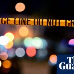 yellow police tape in front of two police cars with lights on at night