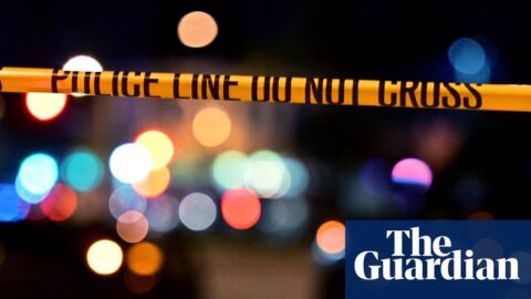 yellow police tape in front of two police cars with lights on at night