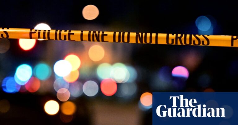 yellow police tape in front of two police cars with lights on at night