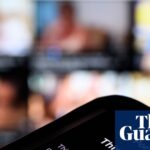 A smartphone screen displays a Pornhub age-restriction warning in a close-up with a blurred background