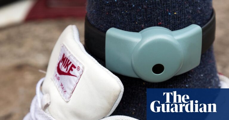 An electronic ankle tag on a person wearing Nike Air Max