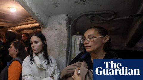 Residents and rescuers take a shelter in a basement of an apartment building in Kharkiv during a threat of another Russian drone strike.