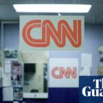 the CNN logo is posted on a small office room
