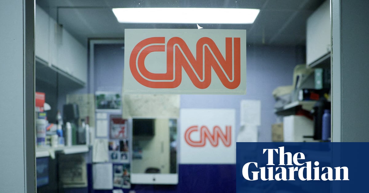 the CNN logo is posted on a small office room
