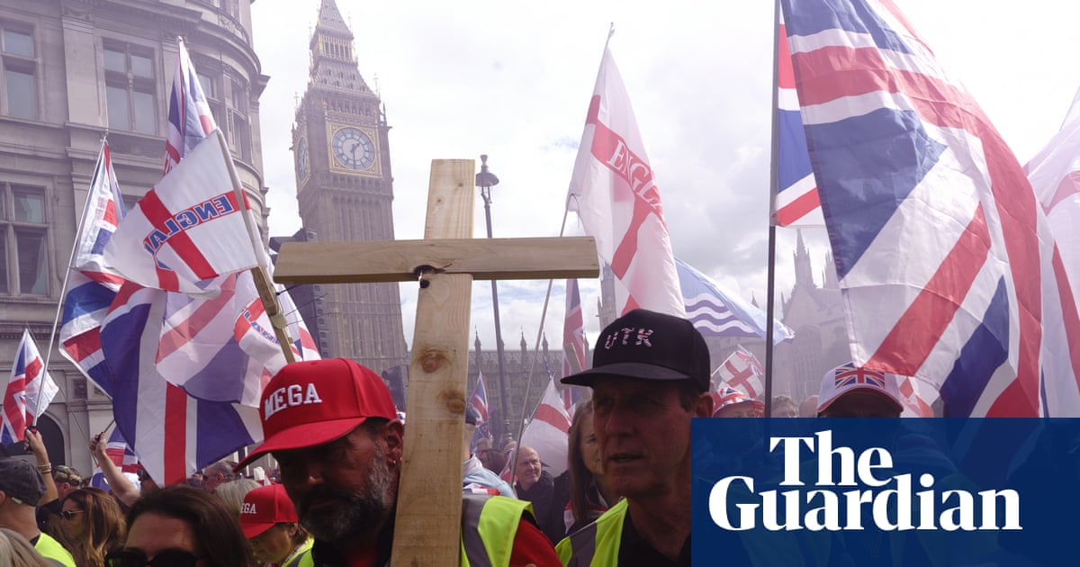 Rally crowd holds a wooden cross and Union Jack flags near Big Ben in London