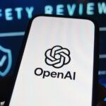 OpenAI logo is shown on a smartphone in front of the words 'safety review'